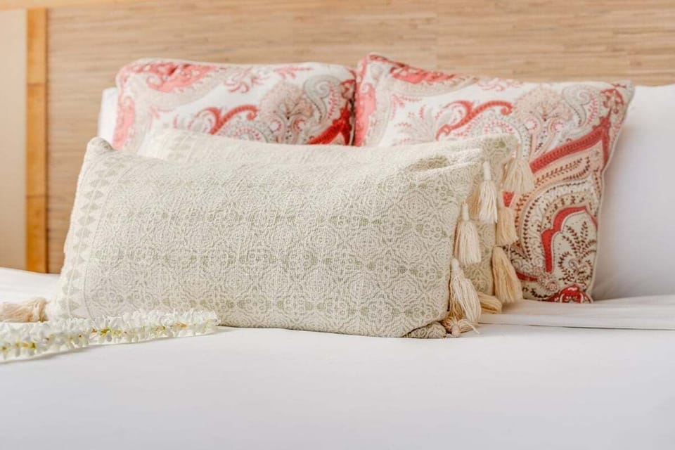 A close‑up of soft, textured bedding with warm patterns and layered pillows that create a cozy, inviting feel.