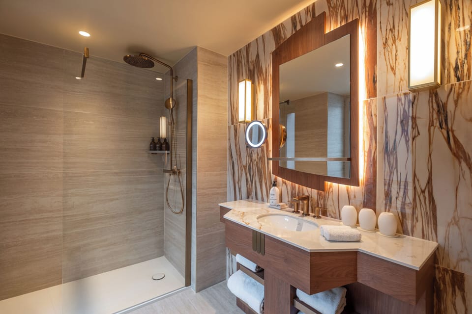 Deluxe Room | Bathroom | Rainfall showerhead, designer toiletries, hair dryer, slippers
