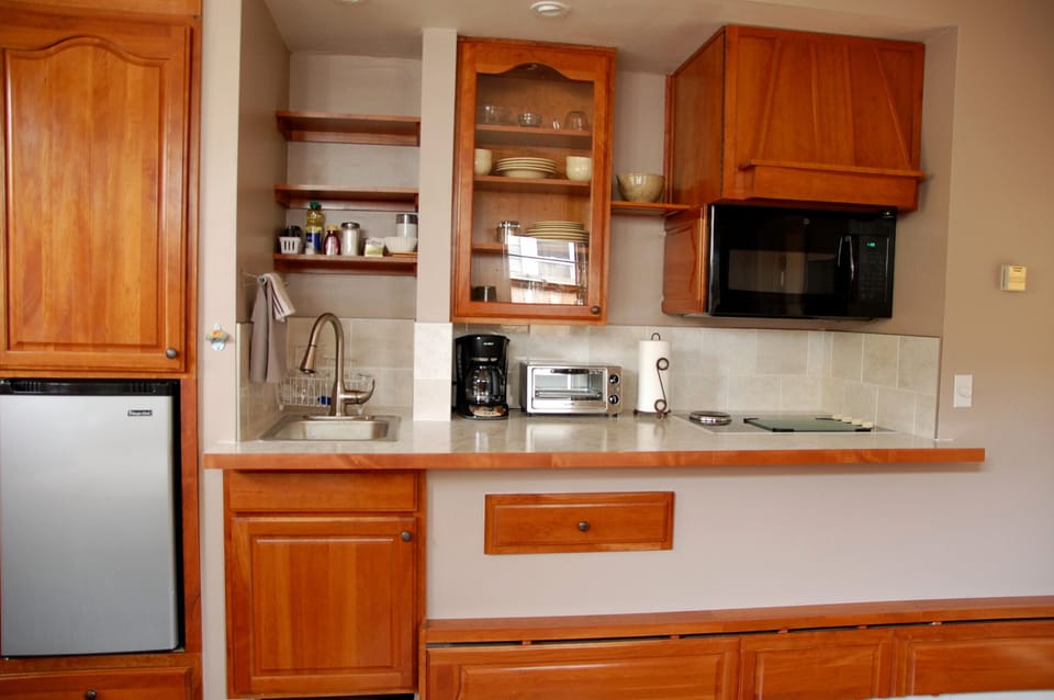 Compact, efficient kitchenette with cooktop; solid cherry cabinetry