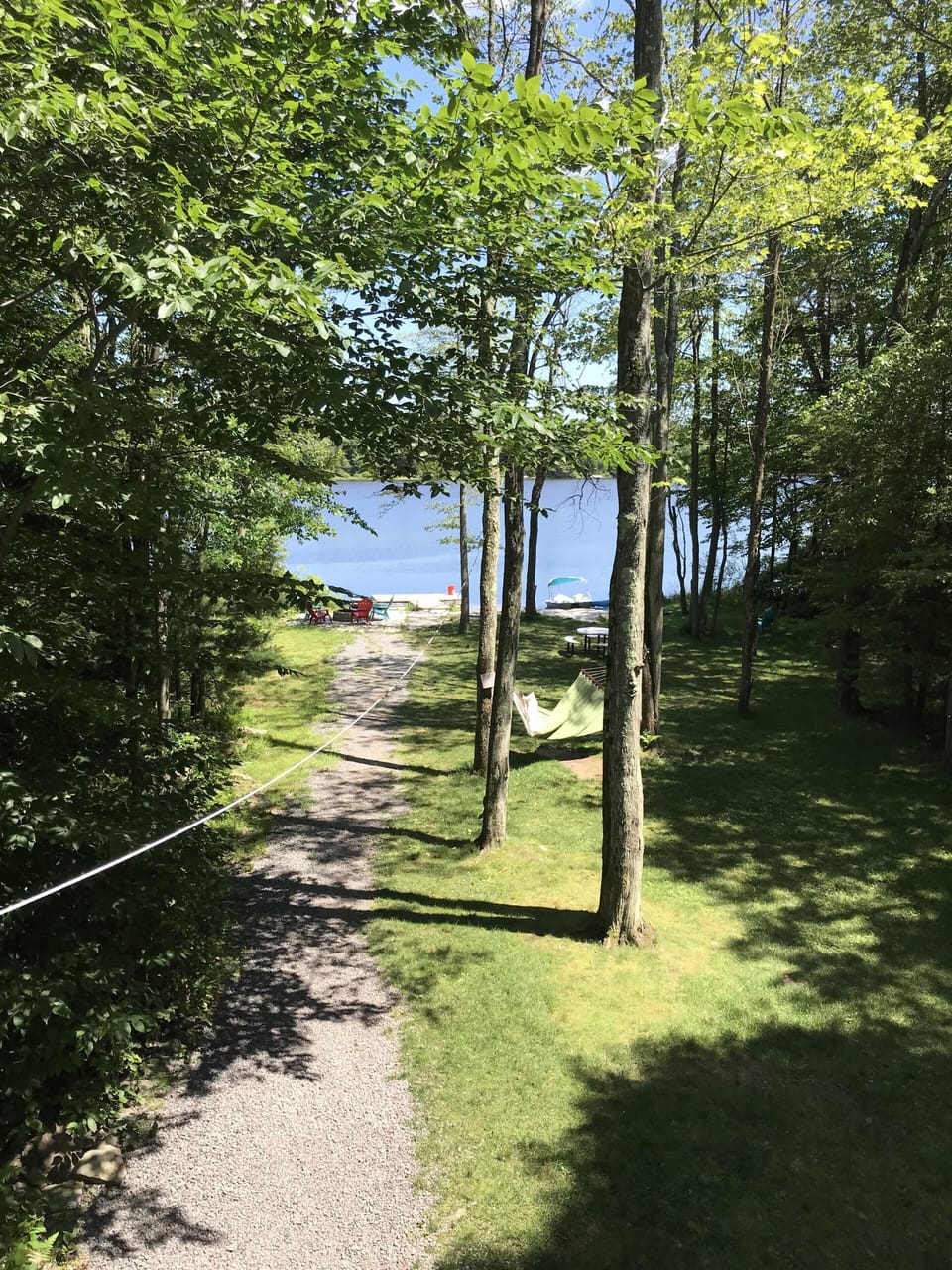 Lakeside fire pit, dock, sandy beach, boats, hammock, and picnic table. 