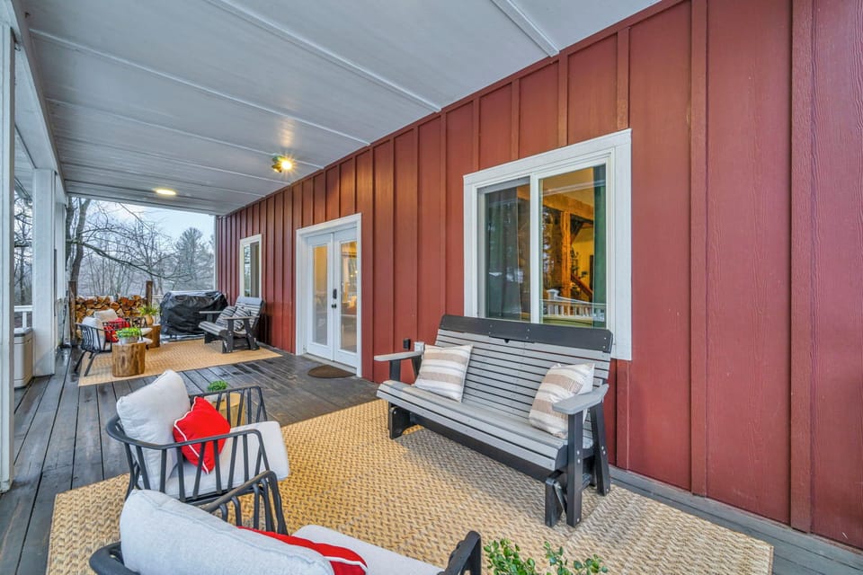 Spacious front porch with grilling and dining, seating 12–16, overlooking tree-lined views. Includes a propane griddle and firewood for both outdoor and indoor fires, perfect for gatherings, meals, and relaxing in nature.