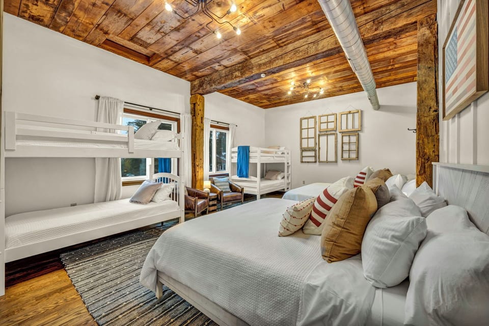 Bedroom 3: A cozy retreat made for memories together ✨ Featuring warm wood ceilings, 2 king beds, and 4 twin beds, with plenty of space for everyone to relax, recharge, and enjoy a comfortable group stay.