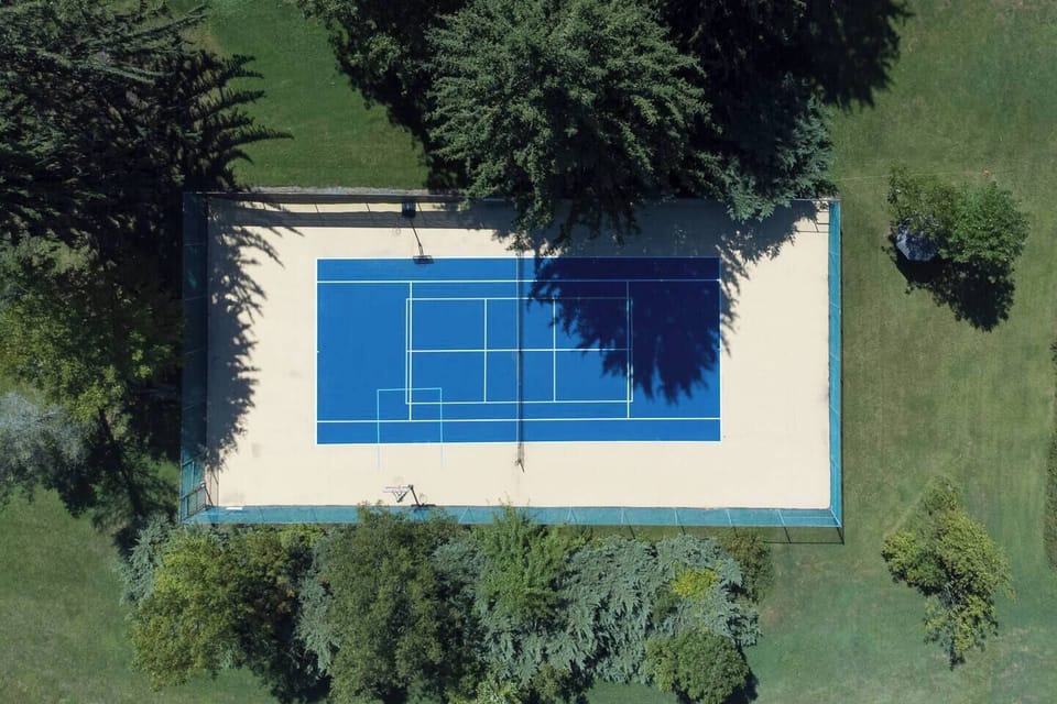 Fenced full-size sports court with shade and spectator benches. Pickleball, tennis, and basketball equipment provided. Bring tricycles or skateboards. Both the sports court and the back fishing pond are shared with Evergreen Retreat.