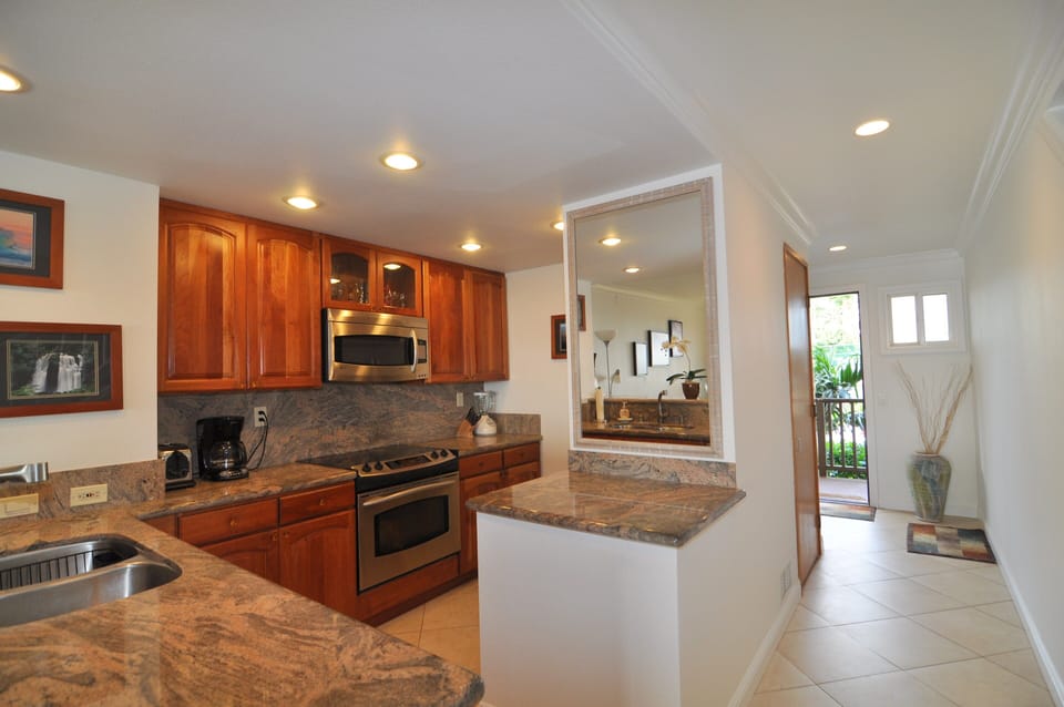 Fully equipped kitchen area - electric range, built-in microwave & dishwasher.