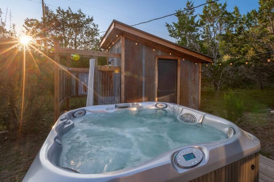 The hot tub is tucked in a private spot behind the cabin with an outdoor shower!