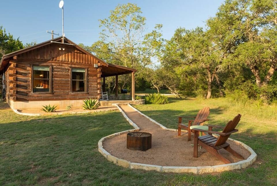 The side yard with wooden chairs around the fire pit