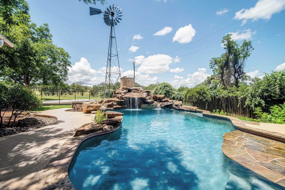 Pool with a stunning waterfall adds a relaxing ambiance to the space.