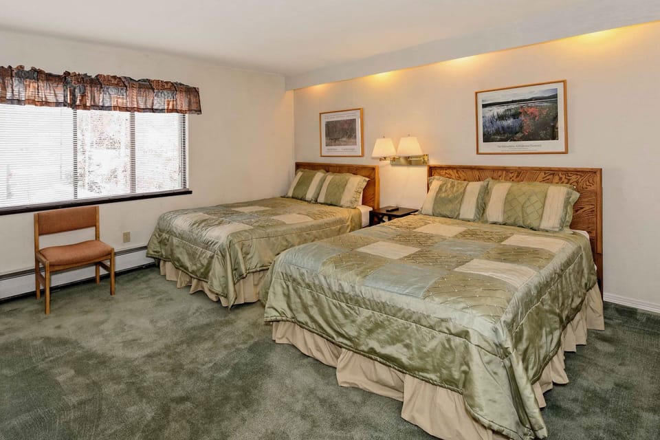 The guest bedroom includes two queen beds, a dresser and closet.