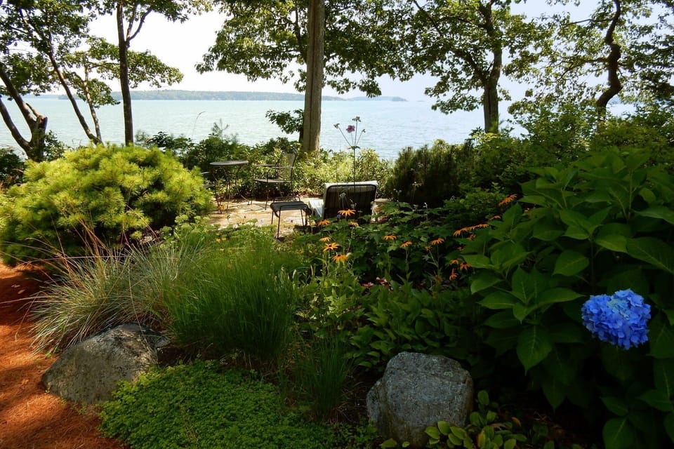 Enjoy coffee and a book on the stone patio in your seaside garden.