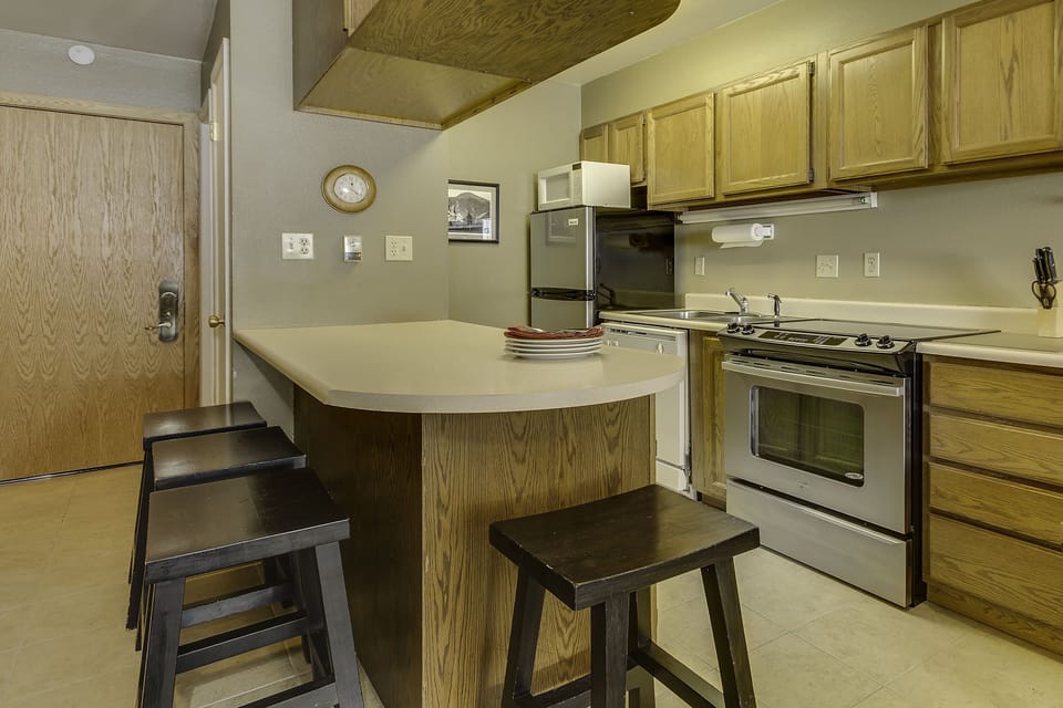 Cook your meals in this handy kitchen w/ fridge, range, microwave, dishwasher.