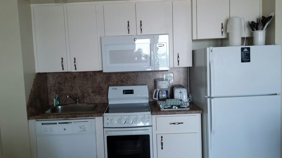 Full kitchen comes stocked with place settings, pots and pans, coffee pot...