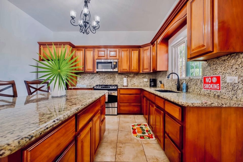 Beautiful kitchen with granite counters, rich cabinetry, and vacation memories.