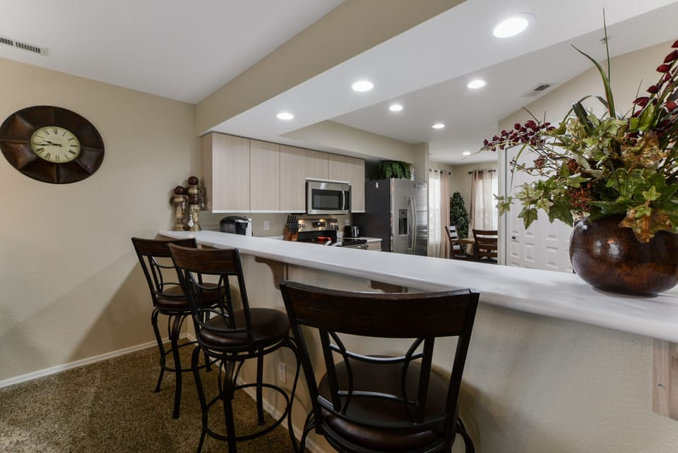 Bar area looking into kitchen with barstools