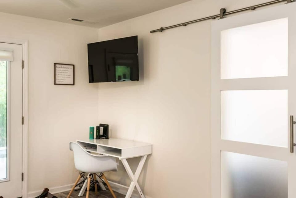 Workspace desk in master, flat screen TV and custom built sliding door entry into master bathroom.
