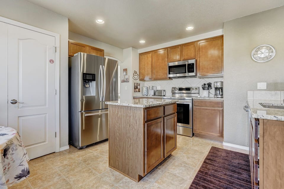The modern Kitchen boasts granite countertops, abundance of cookware & utensils.