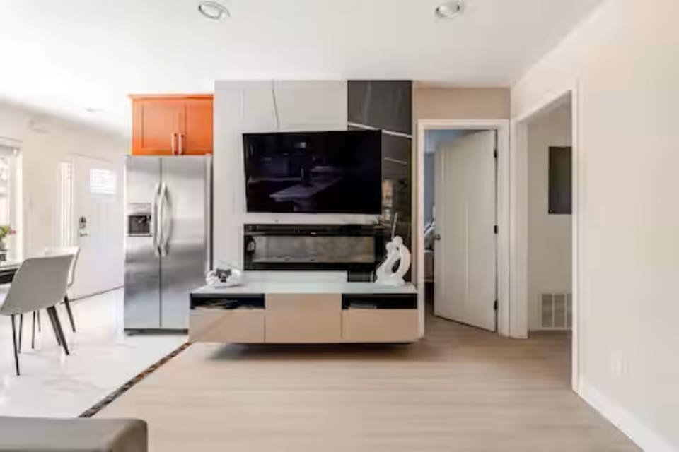 Living space: Accent wall with smart 55"TV, sleek fireplace, & floating stand