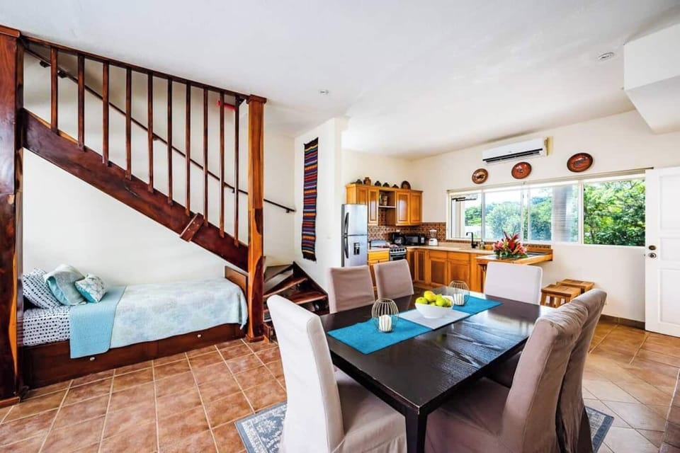 Dining table connecting kitchen to stairs leading up to second floor and rooftop terrace at this Tamarindo condo near town center. Enjoy meals together before heading upstairs for sunset drinks or stargazing from your private perch.