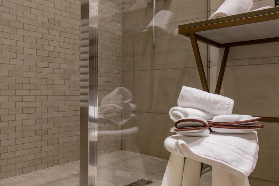 Shower, designer toiletries, hair dryer, slippers