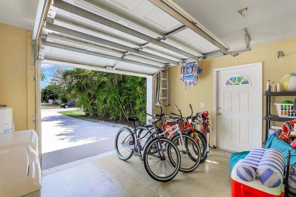 Three adult and one child's bike,  beach chairs, beach umbrella, cooler, and lots of beach toys