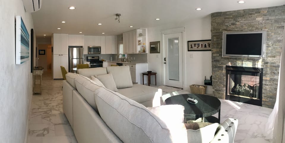 Living room with show stopping indoor/outdoor fireplace.