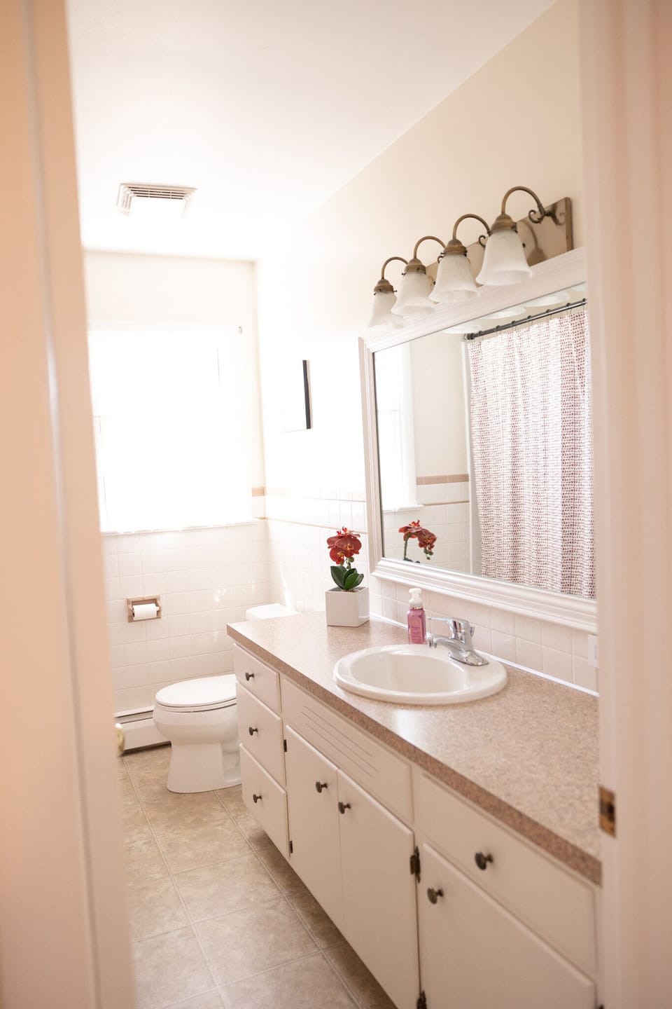 A beautiful and airy full bathroom that is fully stocked.
