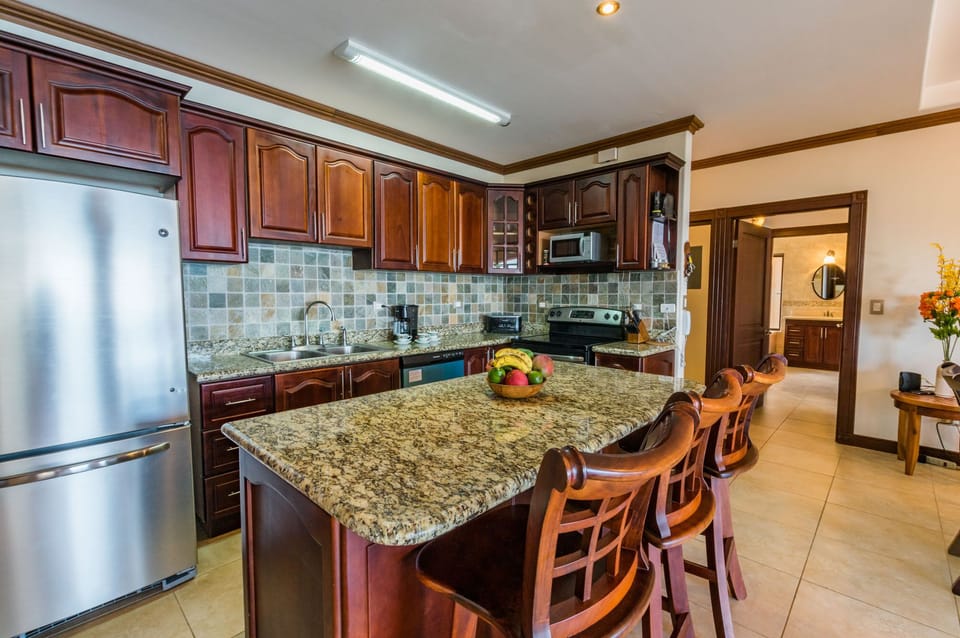 Kitchen with granite countertops and island with bar stools