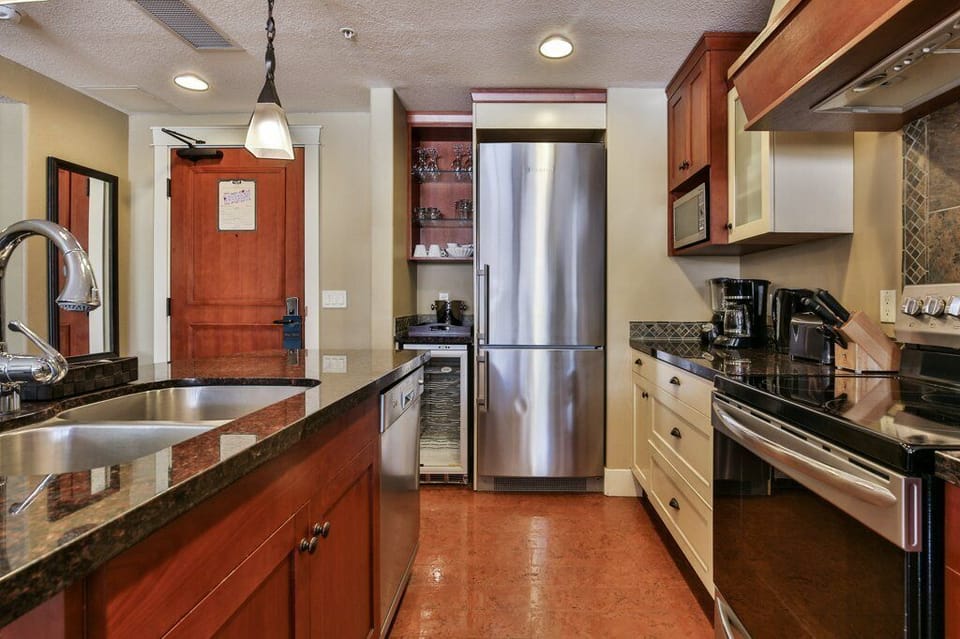 The gourmet, eat-in kitchen is fully stocked and features a wine fridge, and stainless steel appliances.
