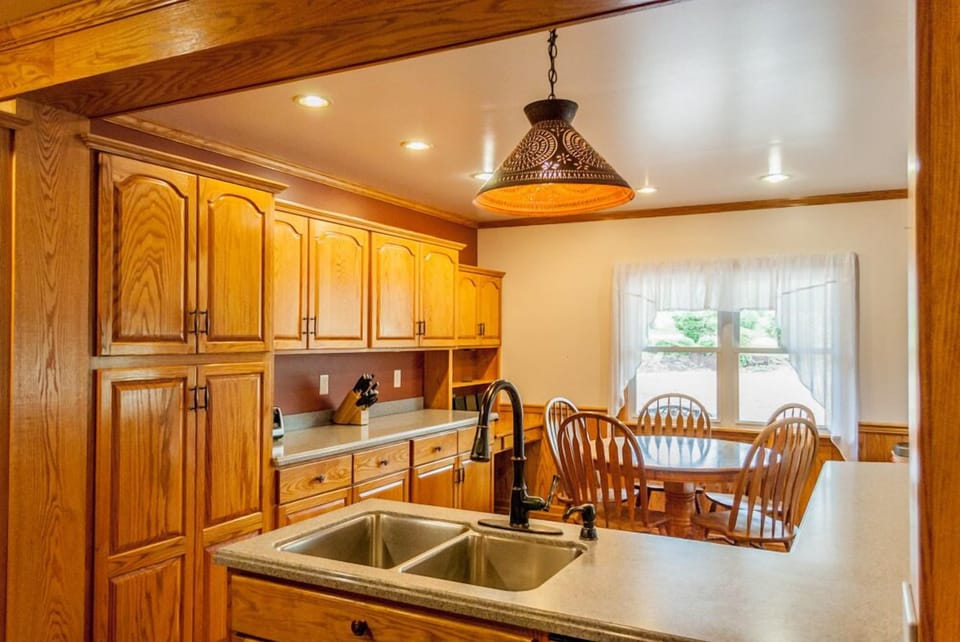 Wooden dining table with cabinets and sink.