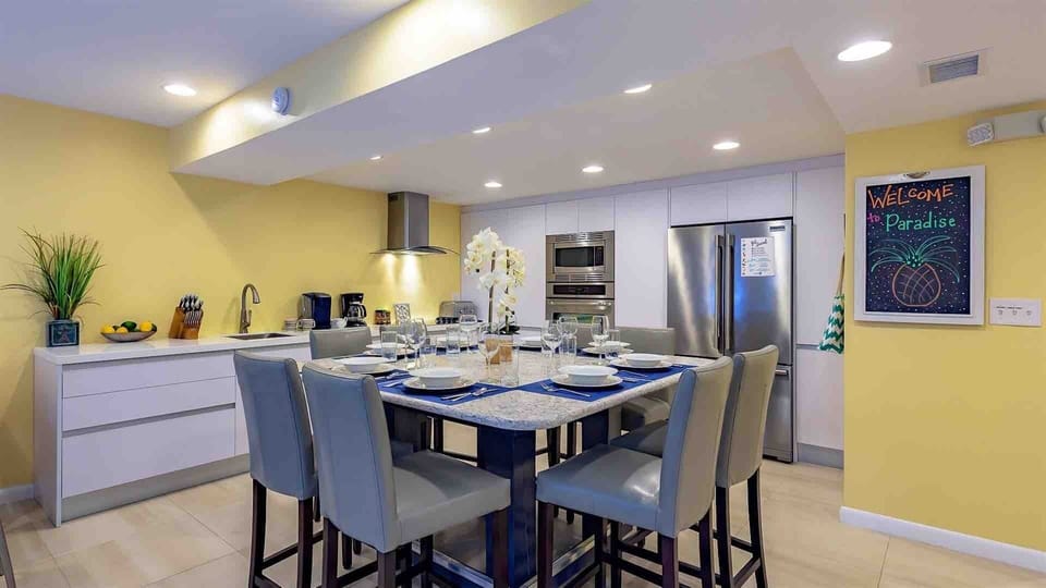 The renovated kitchen includes a large bar height dining set..