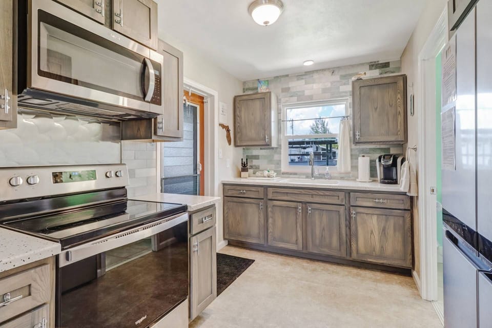 The beautiful, newly remodeled and upgraded kitchen offers a peaceful view of the canal at the back of the cottage.