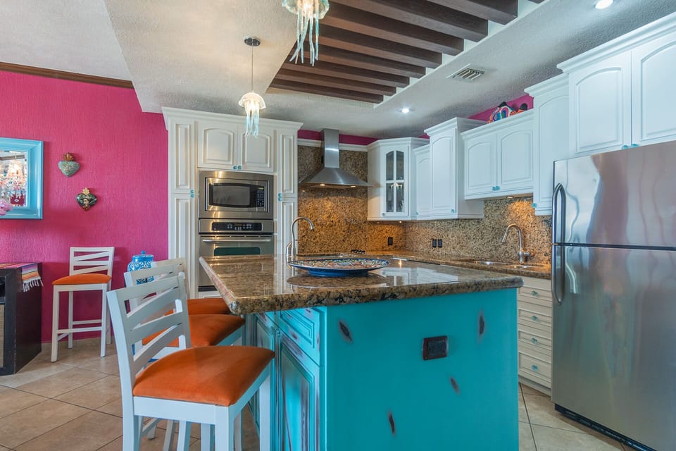 The kitchen with its distressed island and high back chairs.