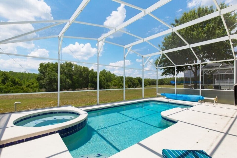 Private pool with spa, overlooking serene and open greenery.