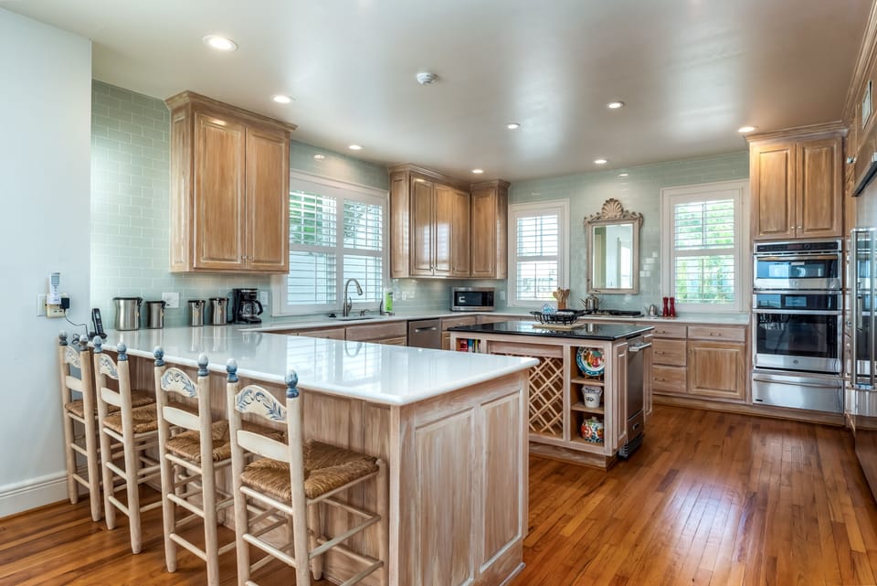 Modern chef's kitchen with stainless steel appliances, quartz countertops, and a center island