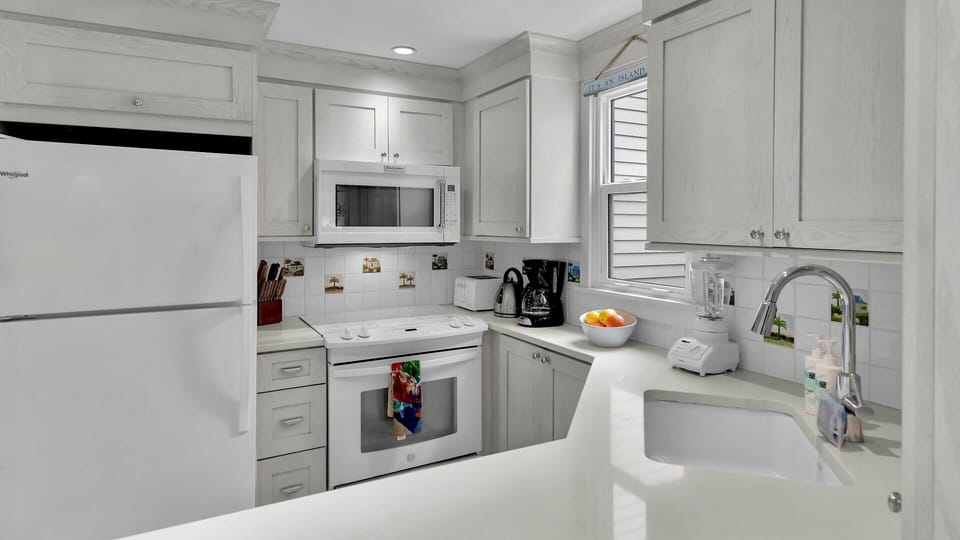 Your fully equipped kitchen awaits with crisp white cabinetry, granite counters, and stainless appliances—perfect for cooking memorable meals together.