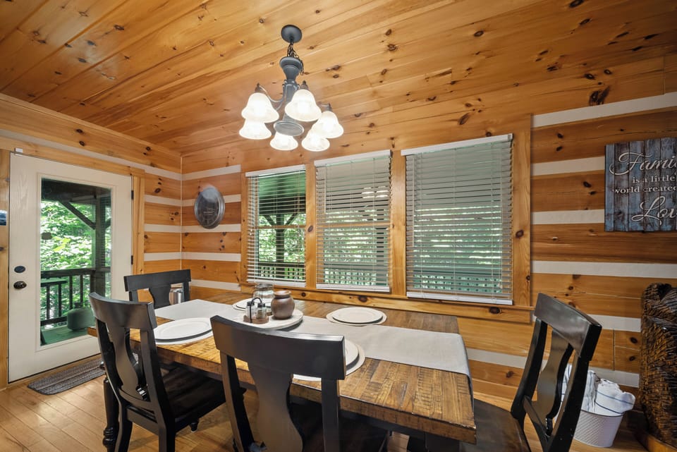 Gather the whole crew around the farmhouse table under warm knotty pine walls and soft chandelier light.