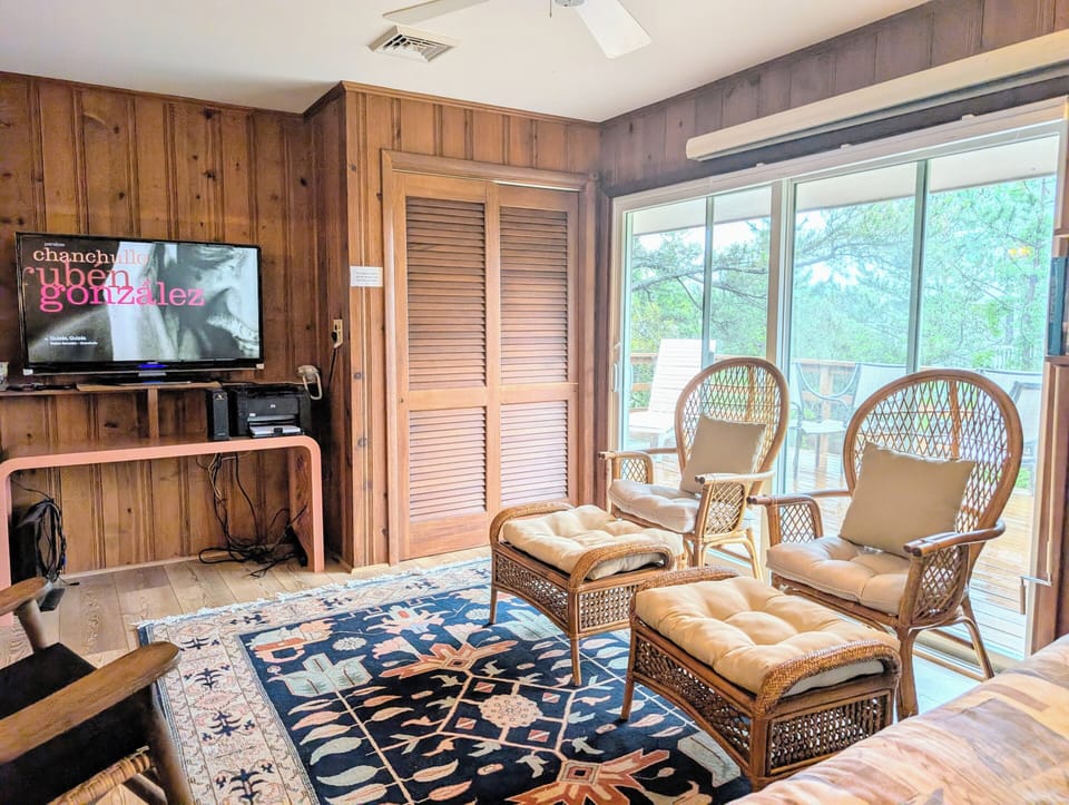 29554 N. Duneway - Cotton Patch East - Entertainment and Sitting - A view of the sun-lit entertainment space showcasing warm wood walls, a TV setup, and plush, comfortable seating.