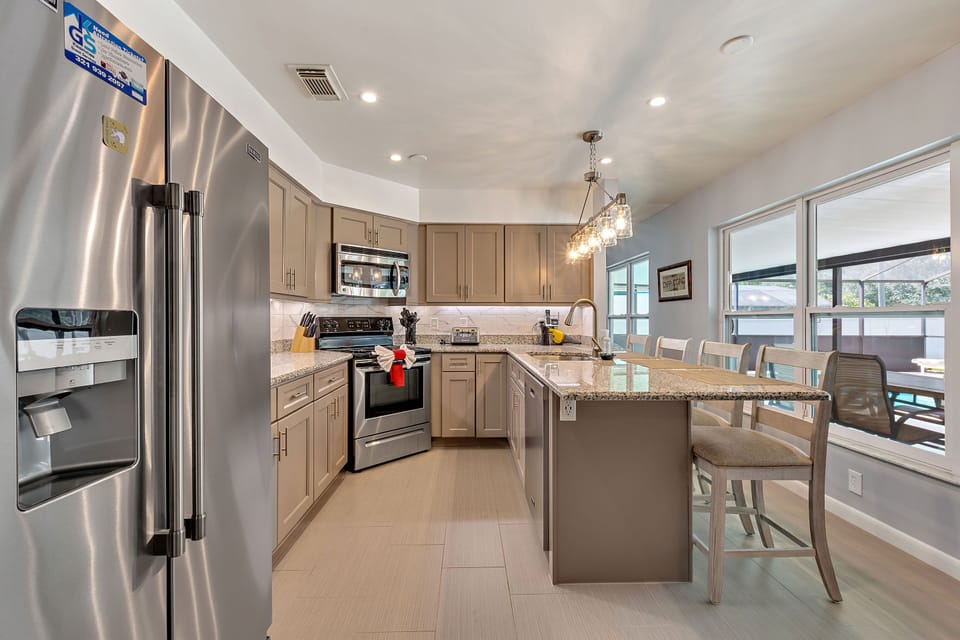 Fully equipped, stylish kitchen with sleek appliances and a breakfast bar for dining.