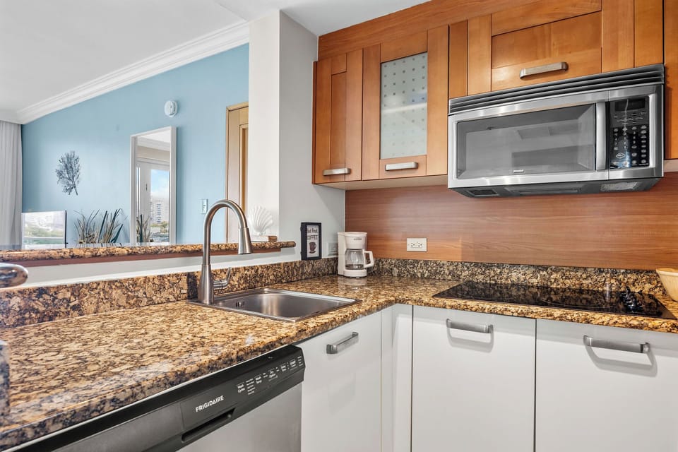 The kitchen features a microwave, 4-burner stove, dishwasher and coffee maker.