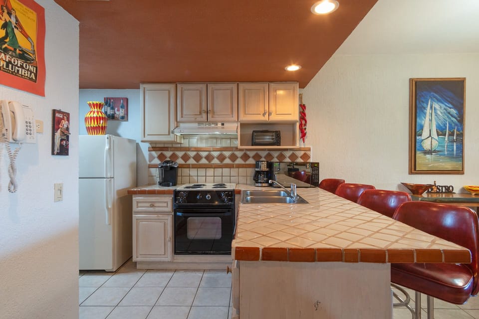 THe counter in the kitchen has four bar stools.