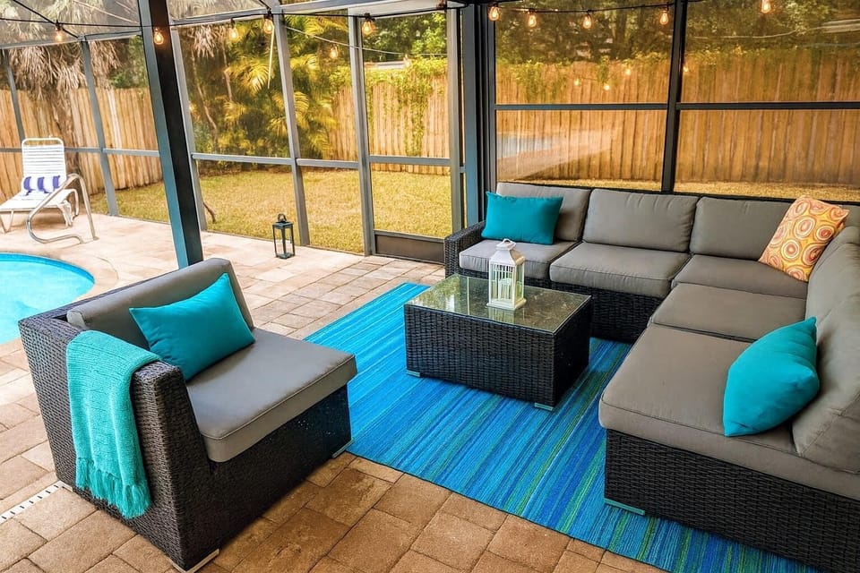 Cozy screened patio with plush seating and pool views