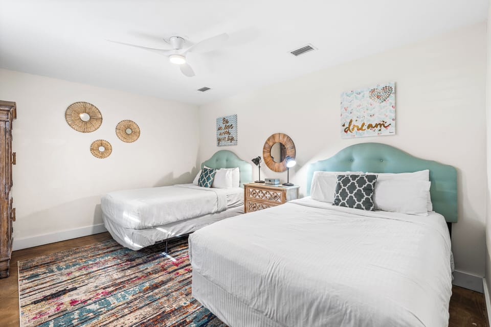 East end of Seabreeze has a 2nd bedroom with 2 queen beds & adjacent full bathroom with a walk-in shower.   TV located above the chest of drawers