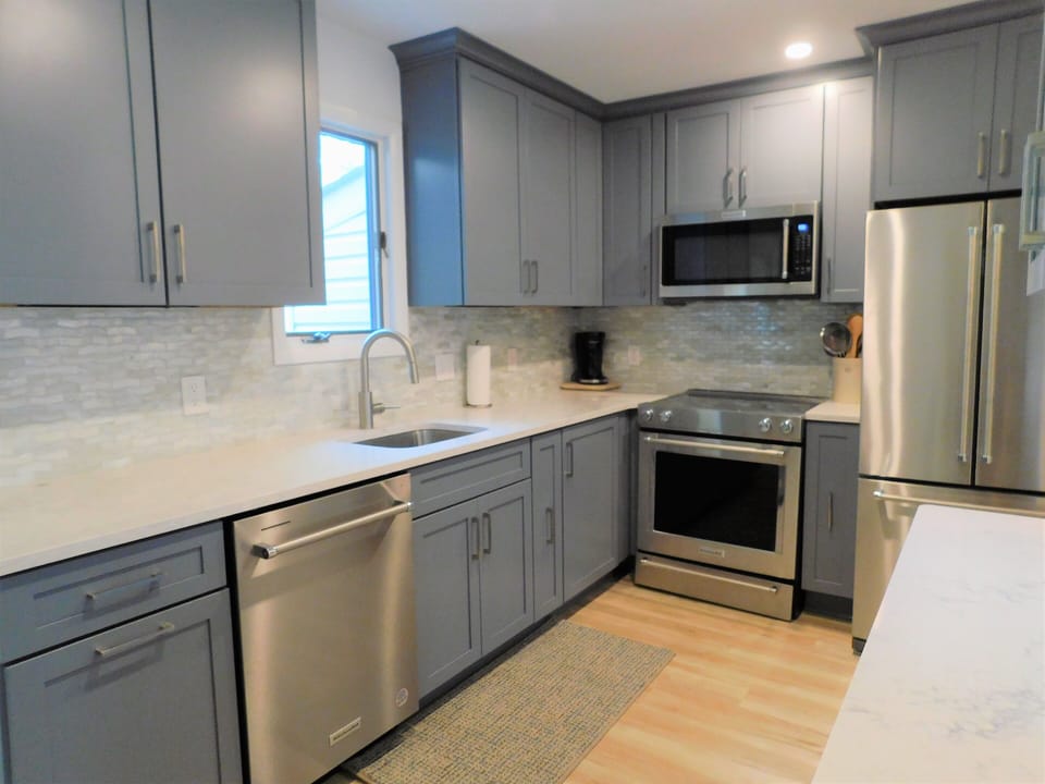 414 Bethany Pines, Bethany Beach - kitchen - Sleek kitchen featuring slate blue cabinetry, white countertops, and stainless steel appliances.