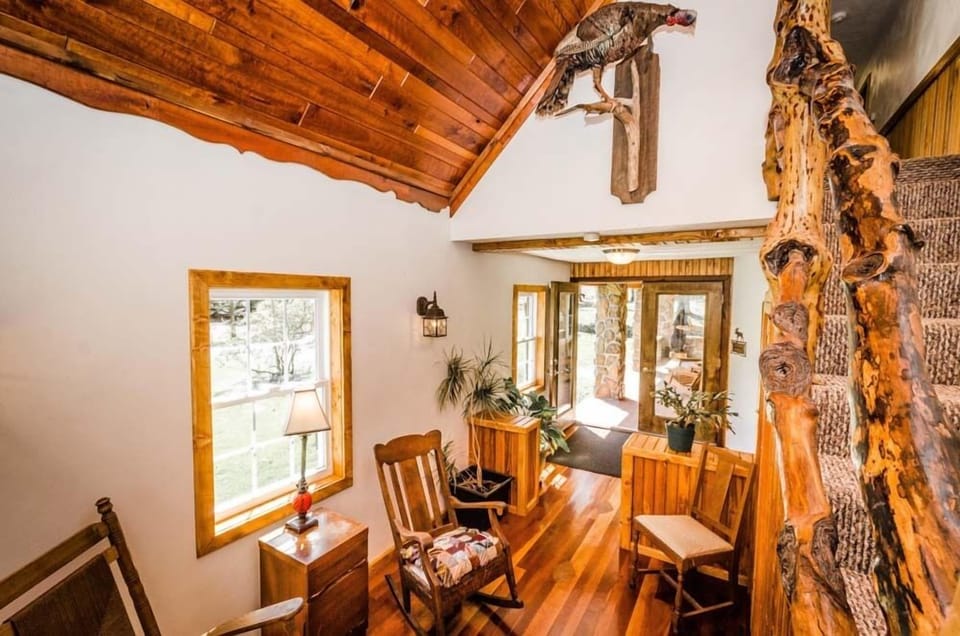 Living Area - Main Level. Cozy living area with rocking chairs and windows showing the beautiful surroundings.