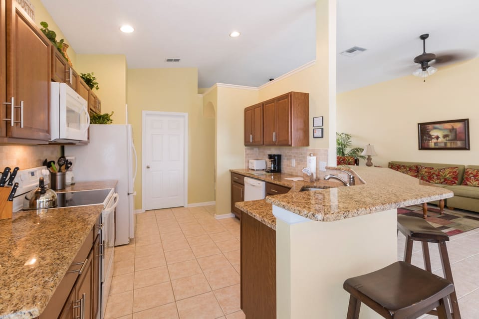 Spacious and fully equipped kitchen with a breakfast bar and dining area.