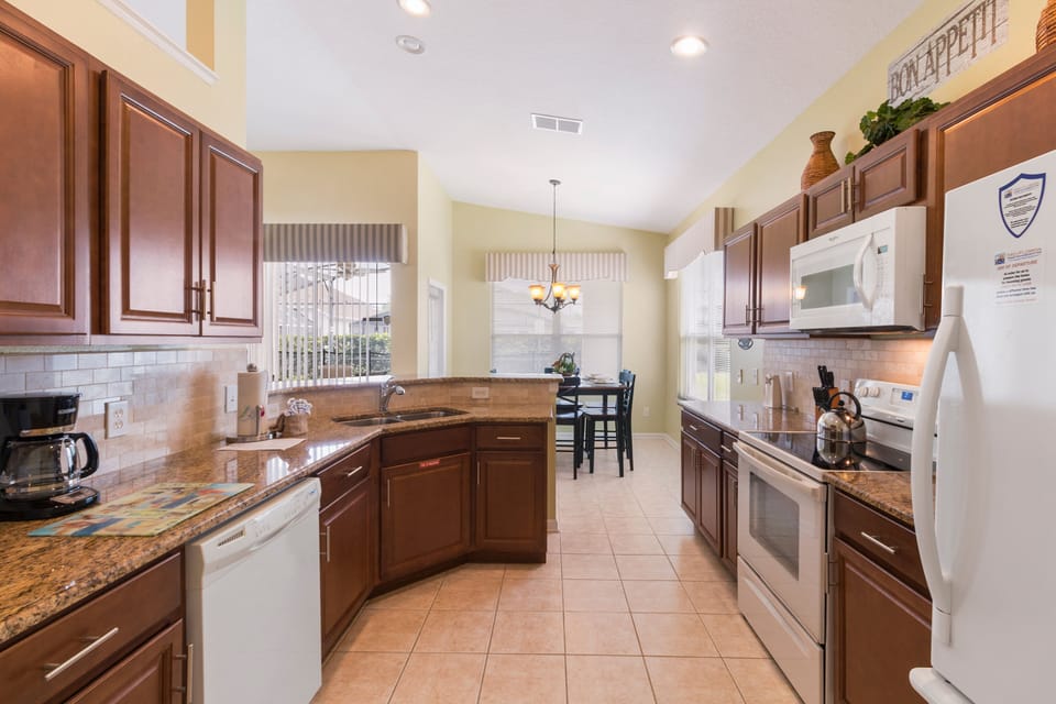 Modern kitchen with granite countertops and all the essentials for home cooking.