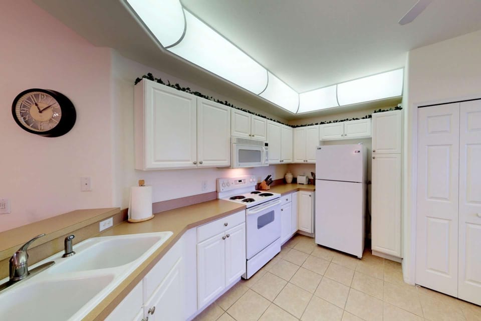 Full size appliances, ample cabinet space, and a conveniently located washer and dryer (behind doors) create a useful kitchen space.