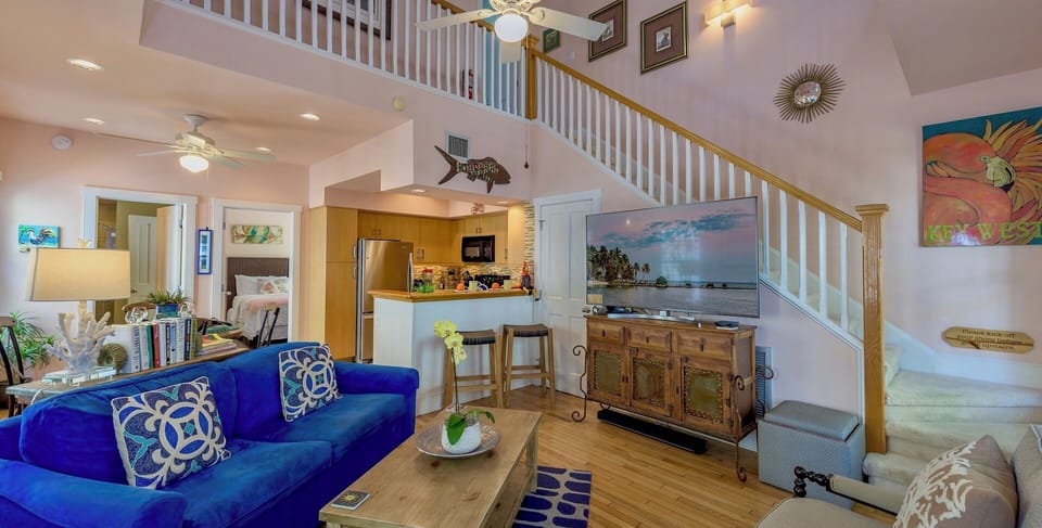 The living area features tall ceilings, bright colors, and upscale furnishings...