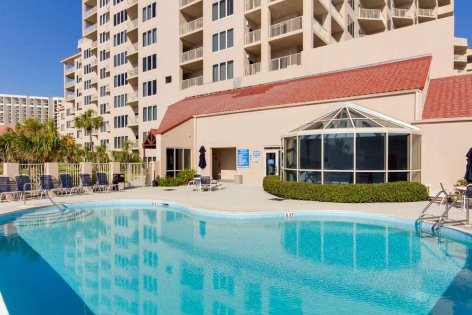 Community pool /exterior lounge seating with indoor seating inside the atrium.