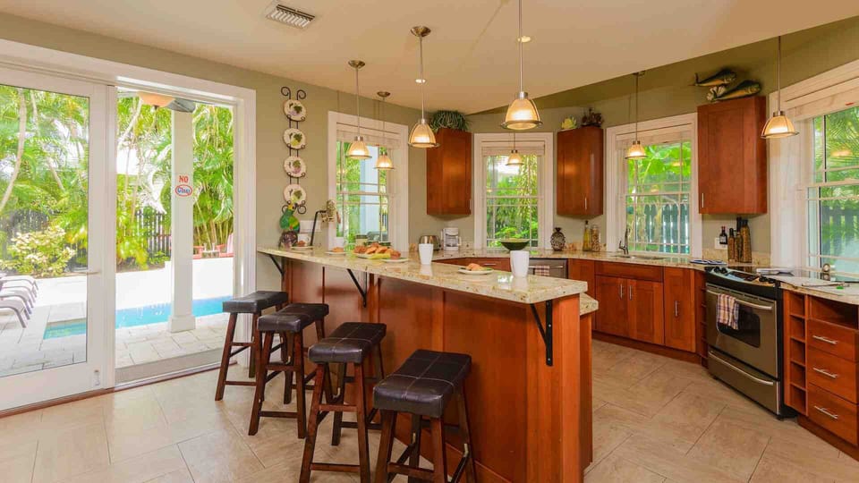 The open kitchen is equipped with luxury appliances and bar seating for 4...