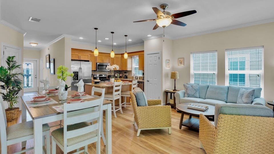 Step into your bright, open-concept retreat where coastal charm meets comfort. Gather around the dining table, whip up meals in the well-equipped kitchen, and unwind on soft seating—your perfect home base awaits.